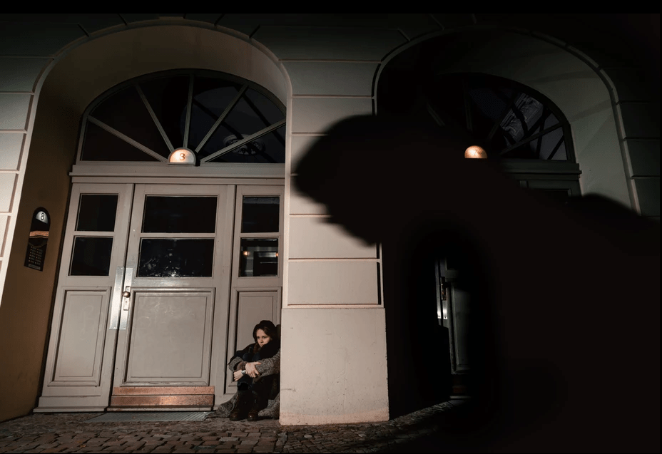 Woman sitting on a street in Berlin at night