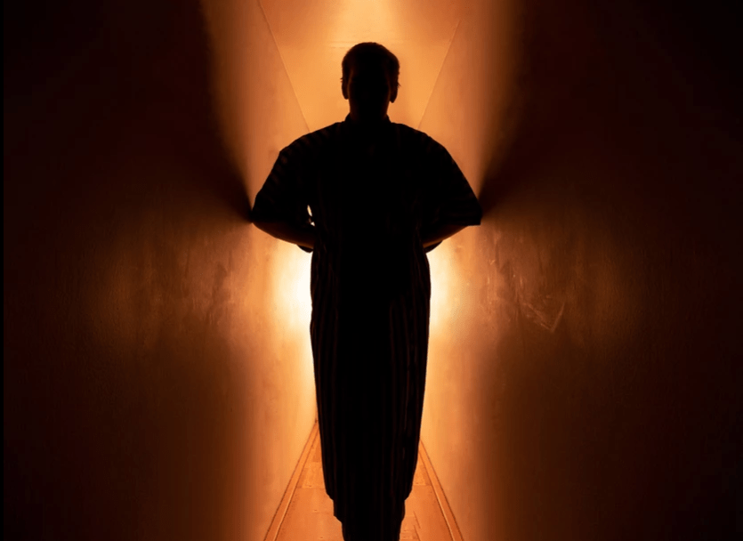 Dark photo of a man in a narrow corridor. Emotions in photography