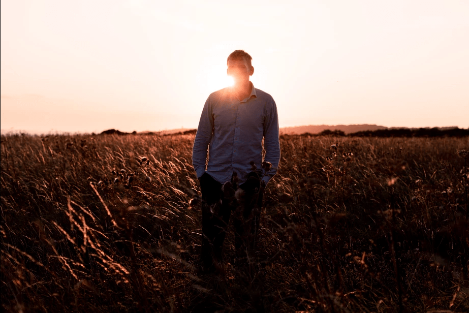 Photographer Fedor Vasilev standing in a field at sunset for a tutorial "Improve photography skills"