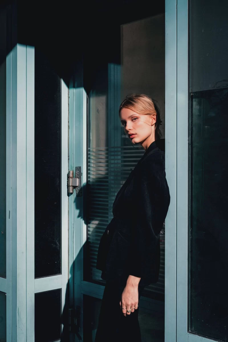 Portrait photography in Berlin in 2022: A woman standing by a glass door