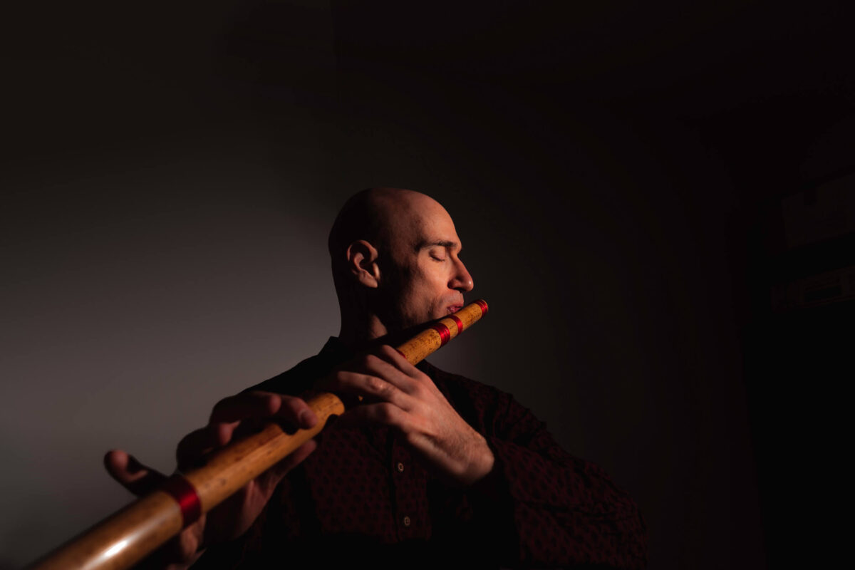 Portrait photography in Vienna: a musician playing on a flute in studio