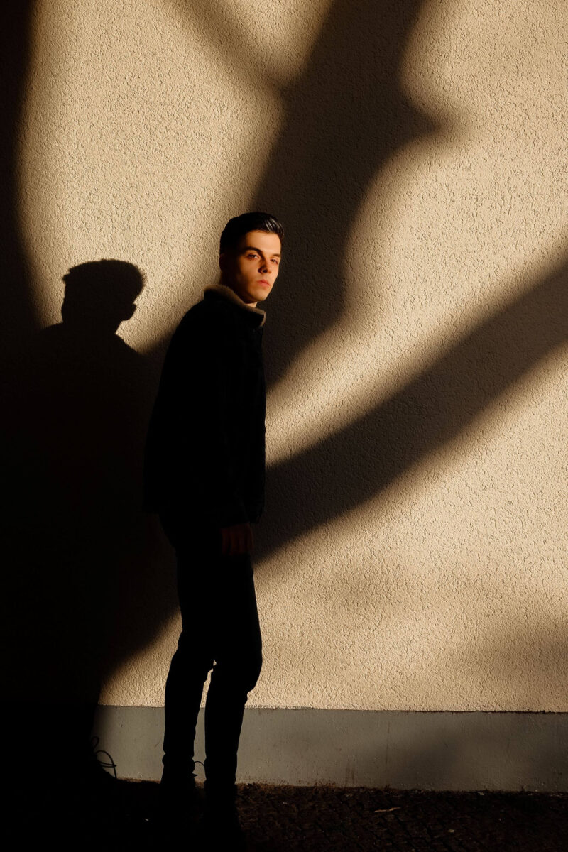 Portrait photography in Berlin: photo of a man in front of a yellow wall
