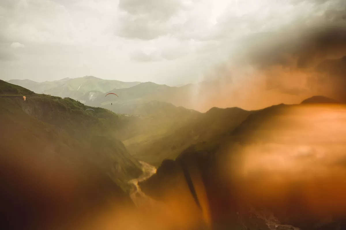 Travel photograph of Georgian mountains with paraplanes