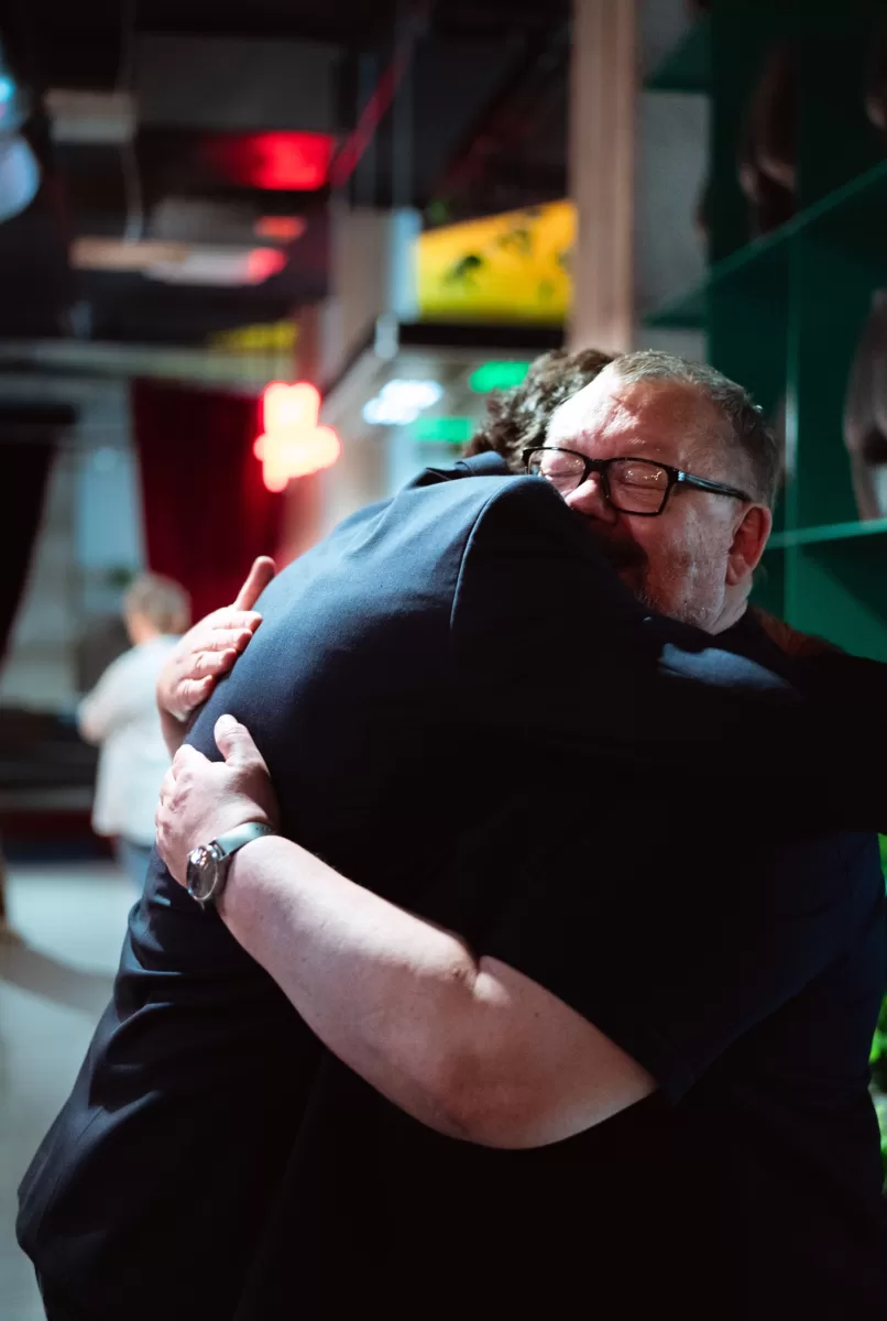 2 men hugging on a cultural event in Vienna by photographer Fedor Vasilev