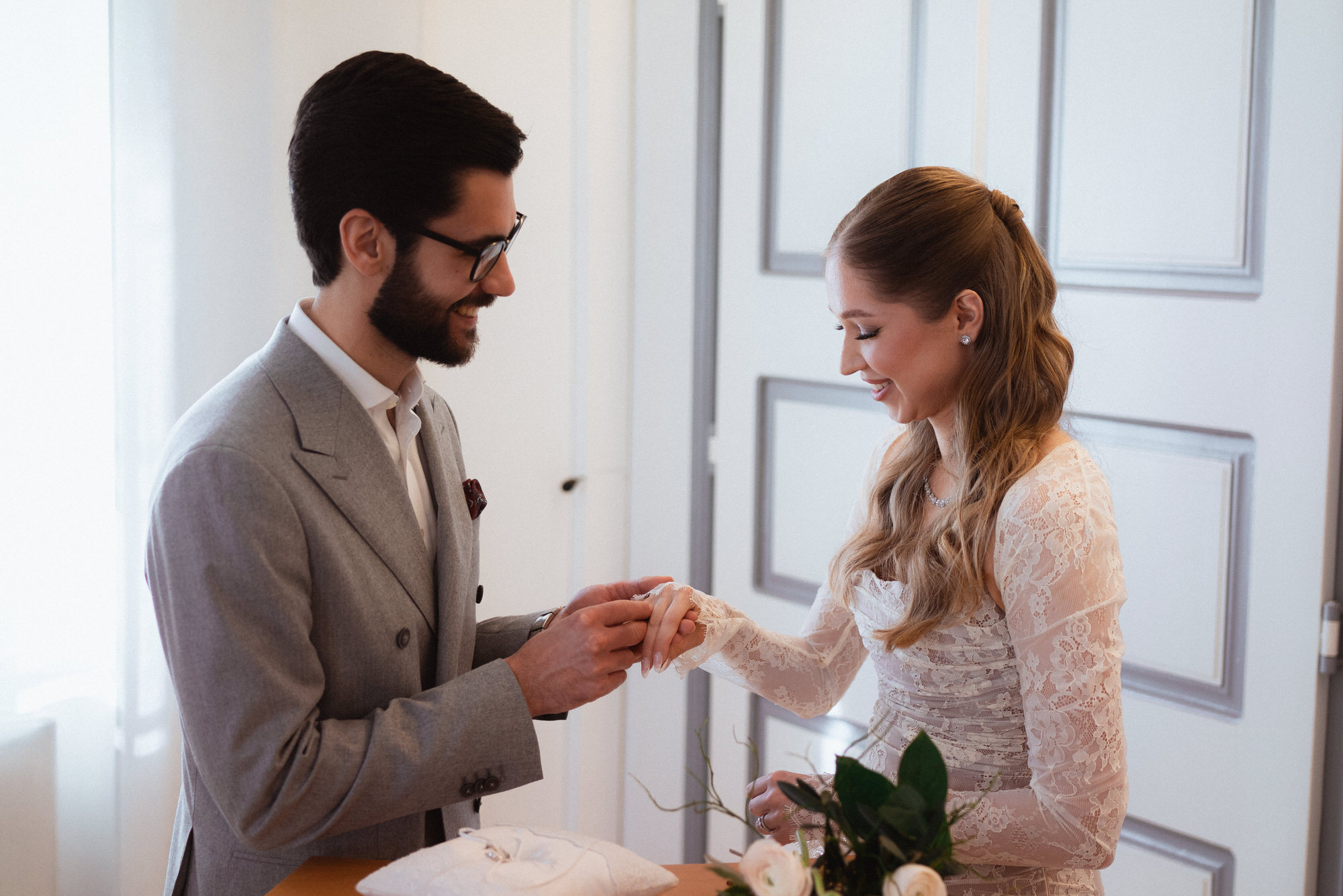 groom putting ring on brides hand